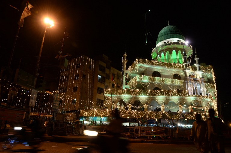 Pakistani people walk in front of a decorated mosque for Eid Milad-un-Nabi (Birth of the Prophet) festival in Karachi on January 12, 2014. A Pakistani court has sentenced a British man to death for blasphemy. u00e2u20acu201d AFP pic