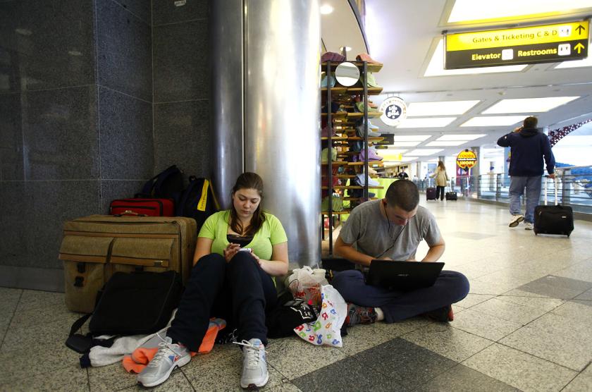 Kayla Hoff uses her phone and Brandon Hoff works on his computer in terminal C at LaGuardia Airport, after their flights were delayed due to snowy weather in the Queens borough of New York, February 4, 2014. u00e2u20acu2022 Reuters pic