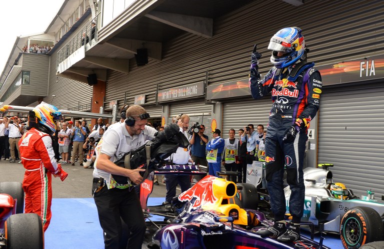 Red Bull Racing's German driver Sebastian Vettel (centre) celebrates winning in the parc ferme beside Ferrari's driver Fernando Alonso (left) and Mercedes' driver Lewis Hamilton at the Spa-Francorchamps circuit in Spa on August 25, 2013. u00e2u20acu201d AFP pic