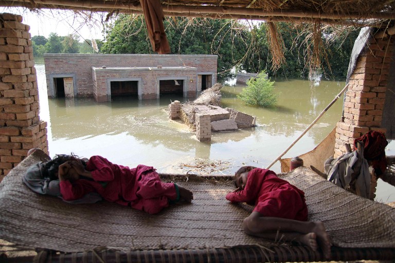 Flood-affected young girls rest on a charpoy at higher ground on the outskirts of Multan on August 21, 2013. u00e2u20acu201d AFP pic