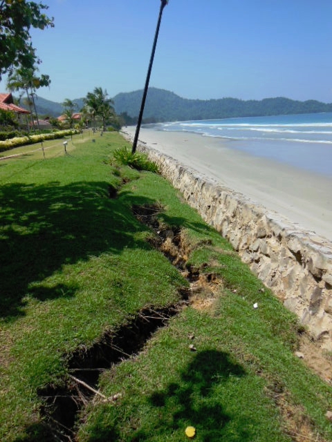 Picture of land erosion behind a seawall erected in front of the villas.