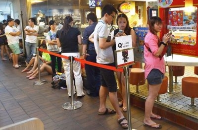 This photograph made available by The Straits Times newspaper on June 27, 2013 shows people waiting in a queue to purchase a Hello Kitty toy in a skeleton outfit at a McDonalds restaurant in Singapore. u00e2u20acu201d AFP-Relaxnews pic