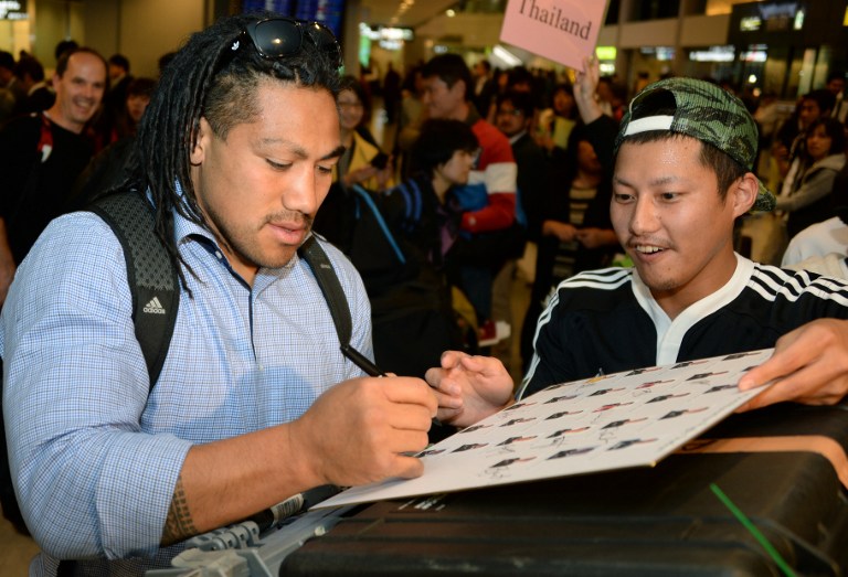 All Blacks rugby union hooker Keven Mealamu (left) signs his autograph for a Japanese fan upon his team's arrival at Narita Airport, in the suburbs of Tokyo, on October 28, 2013. u00e2u20acu201d AFP pic