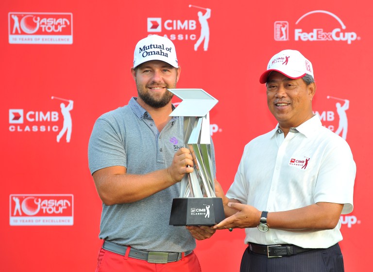 Ryan Moore of the US (left) poses with the winner's trophy alongside Deputy Prime Minister Muhyiddin Yassin after defeating compatriot Gary Woodland in a play-off during the CIMB Asia Pacific Classic golf tournament, October 28, 2013. u00e2u20acu201d AFP pic