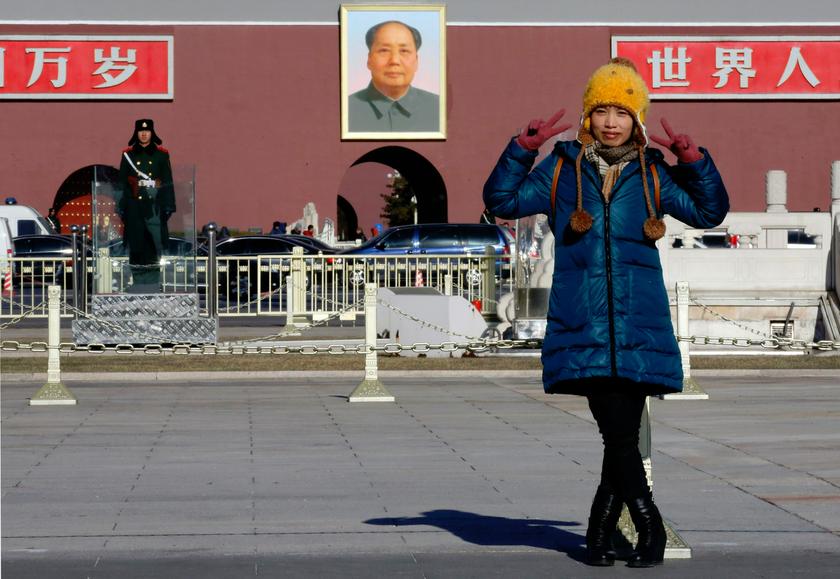 A woman poses for her souvenir picture in front of a large portrait of the late Chairman Mao Zedong at Tiananmen Square in Beijing December 26, 2013. Chinese officials are on alert for possible violence during the coming holidays. u00e2u20acu201d Reuters pic