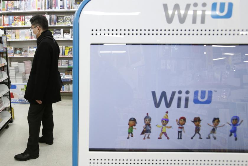 A shopper is seen behind a advertisement board of Nintendo Co Ltd's Wii U game console at an electronics retail store in Tokyo January 30, 2014. u00e2u20acu201d Reuters pic