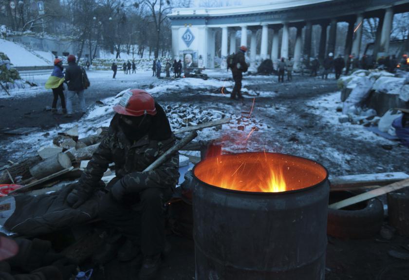 Anti-government protesters gather at the site of clashes with riot police in Kiev. Russian President Vladimir Putin instructed his government yesterday to honour its agreements to lend Ukraine US$15 billion to Ukraine and cut the price of gas it sells to 