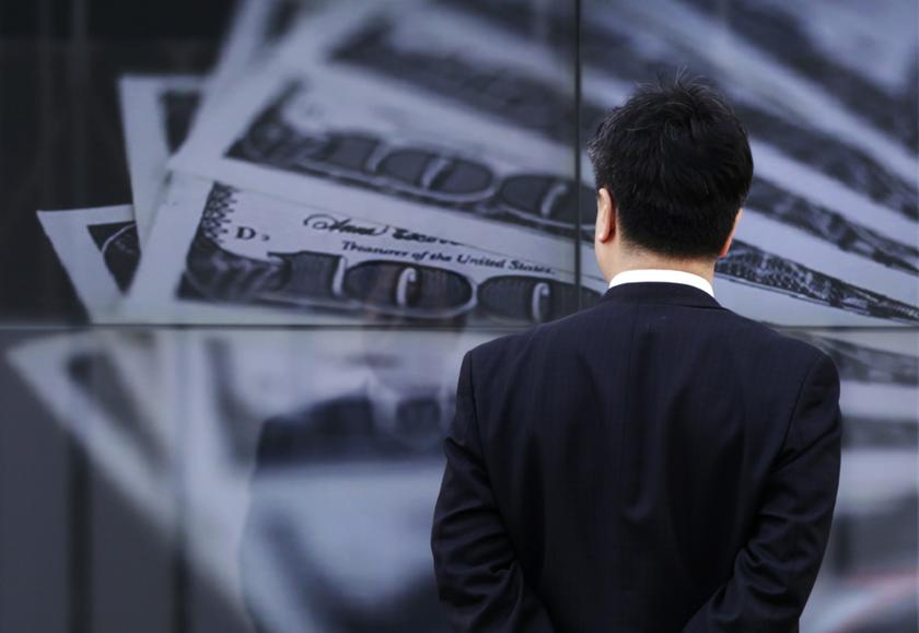 A businessman looks at a screen displaying a photo of 100 dollar bank notes, in Tokyo, in this April 8, 2013 file picture. u00e2u20acu201d Reuters pic