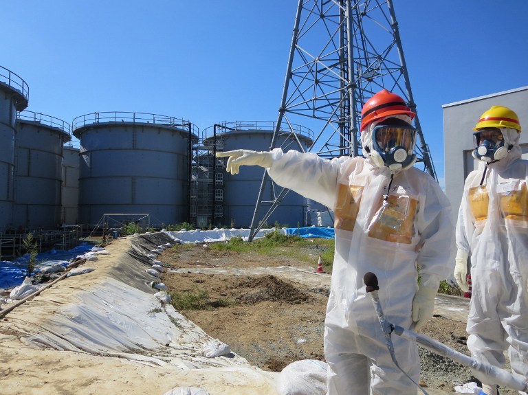 This handout picture taken by (TEPCO) on August 26, 2013 shows Japanese Economy Minister Toshimitsu Motegi (red helmet) inspecting contamination water tanks at TEPCO's Fukushima Dai-ichi nuclear power plant in the town of Okuma, Fukushima prefecture. u00e2u20acu201d 