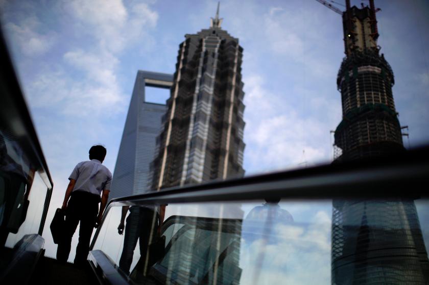 A man rides an escalator near Shanghai Tower (right, under construction), Jin Mao Tower (centre) and the Shanghai World Financial Center at the Pudong financial district in Shanghai July 4, 2013. u00e2u20acu201d Reuters pic
