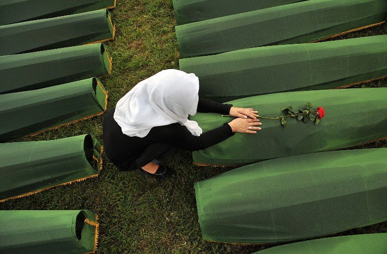 A picture taken on July 10, 2013 shows a Bosnian Muslim woman mourning over the casket of her relative, at a memorial cemetery in village of Potocarion near Eastern-Bosnian town of Srebrenica, on July 10, 2013. u00e2u20acu201d AFP pic