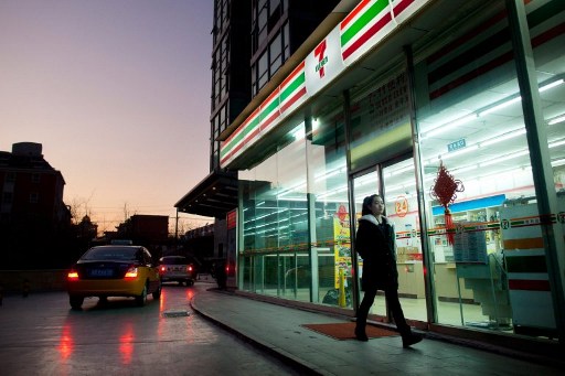 A woman walks past a 7-Eleven convenience store in Beijing on January 3, 2012. u00e2u20acu201d AFP pic