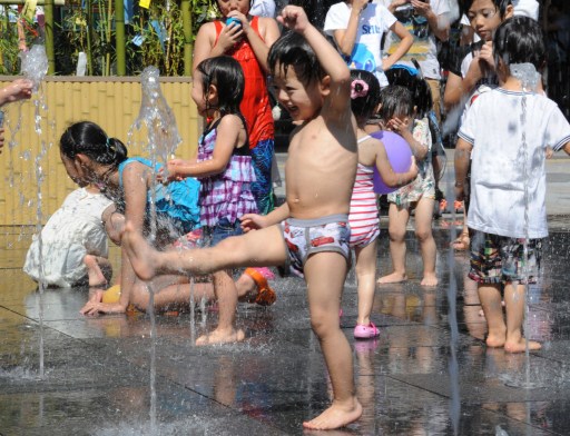 Children play with water fountains in Tokyo on July 7, 2013. u00e2u20acu201d AFP pic