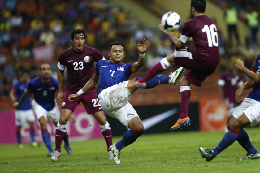 Malaysia's Mohd Aidil Zafuan (centre) fights for the ball with Qatar's Al-Ali during their AFC Asian Cup 2015 qualifying soccer match in Shah Alam, outside Kuala Lumpur, November 20, 2013.  u00e2u20acu201d Reuters pic