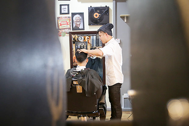 Lex Low cutting and styling the hair of a customer