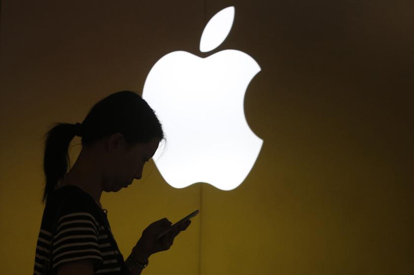 A woman looks at the screen of her mobile phone in front of an Apple logo outside its store in downtown Shanghai. u00e2u20acu201d Reuters pic