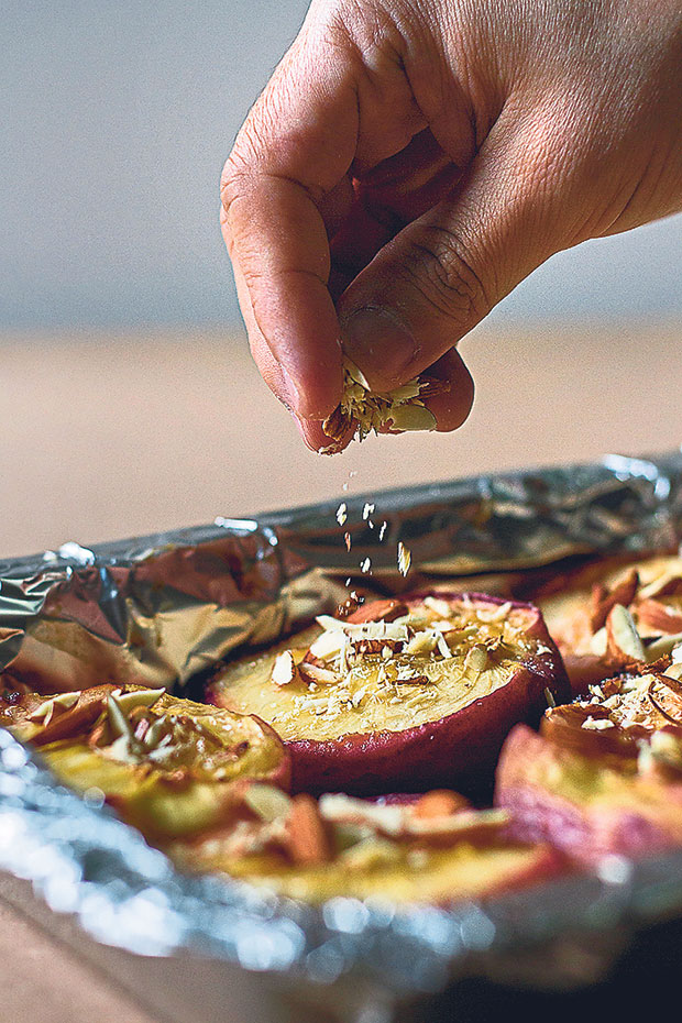 Sprinkle some of the chopped almond flakes into the middle of the baked peaches