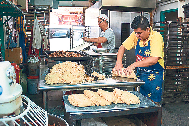 Workers shaping the biscuit dough after adding the spices