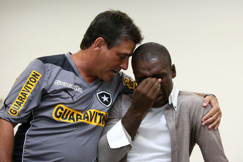File photo shows Dutch soccer player Clarence Seedorf (right) reacting next to Botafogo coach Eduardo Hungaro during a farewell gathering with Botafogo players in Saquarema January 14, 2014. 