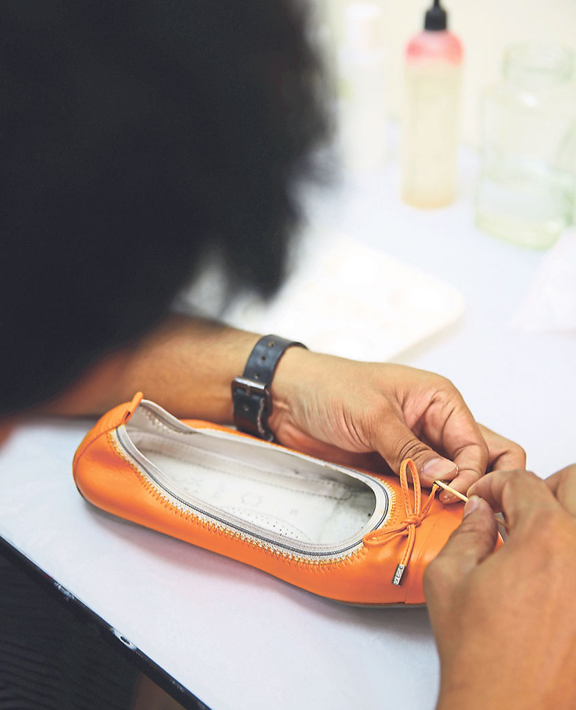 A worker repairs a pair of leather shoes