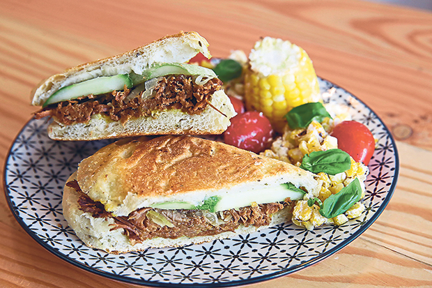 The pulled beef sandwich features melt-in-the-mouth beef brisket and pickled cucumbers