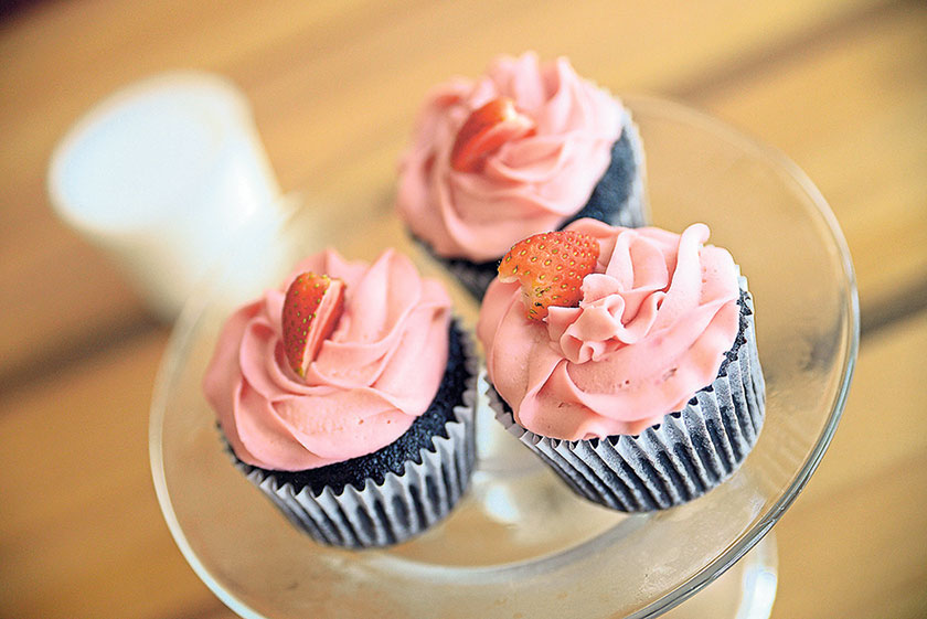 Chocolate muffin with beetroot cream cheese topped with strawberries