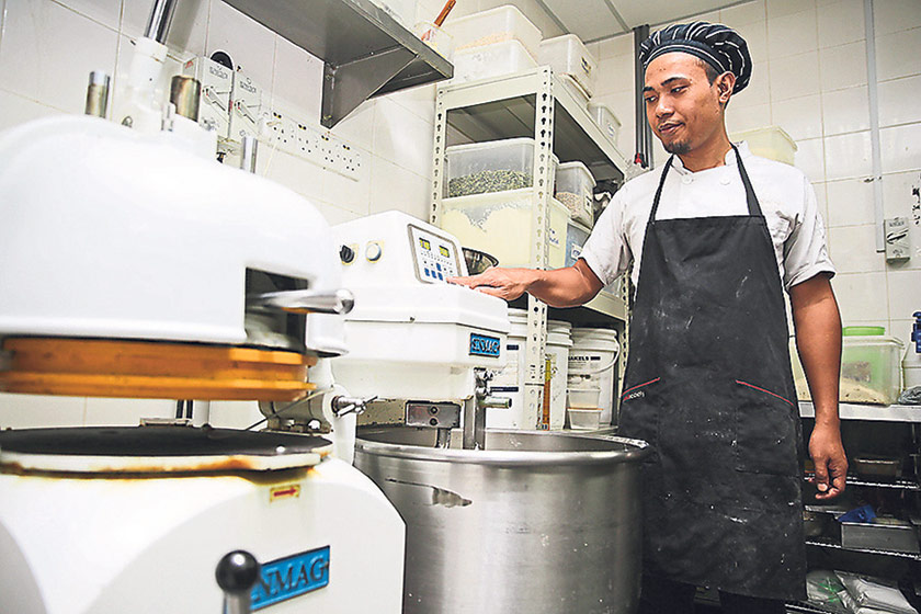 Head baker Nazib watches over the dough mixer