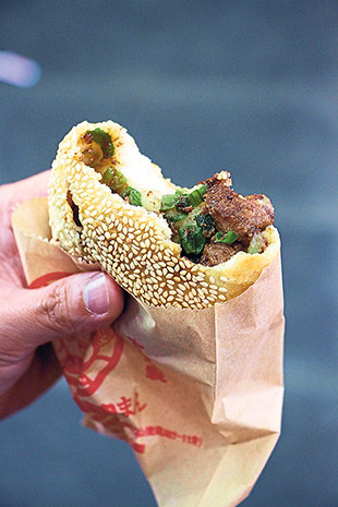 A bite of a pepper bun reveals juicy meat and fragrant scallions.