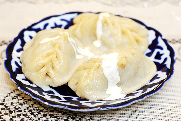Enjoy manti or steamed dumplings filled with juicy minced mutton, onions and cumin drizzled with sour cream.