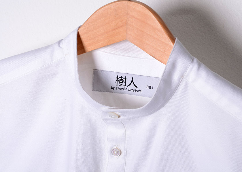 Each of their shirts, like this white Oxford tunic shirt bears the Shuren Projects label in Chinese characters