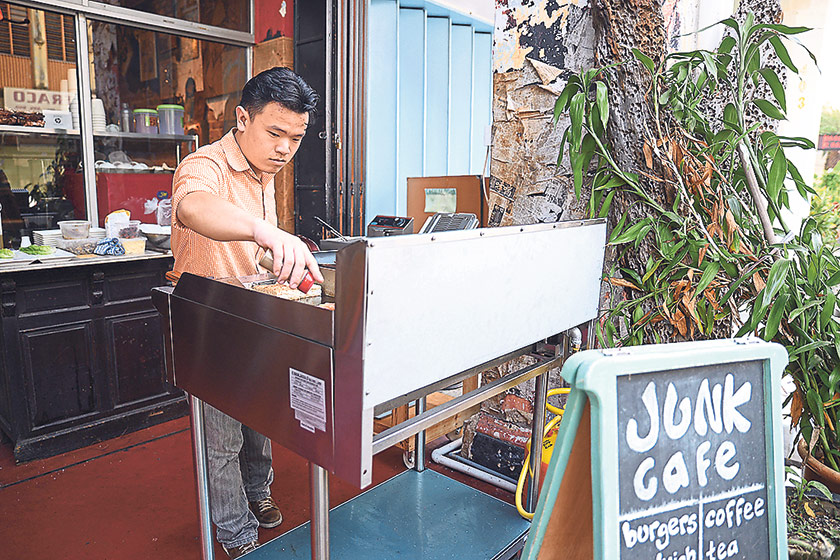 Ong preparing the burger at the entrance of the cafe