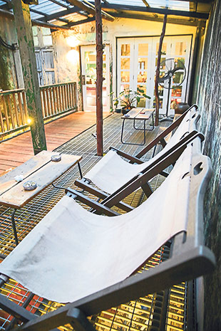 The patio on one side of the “hanging walkway” is lit from below in the evening.