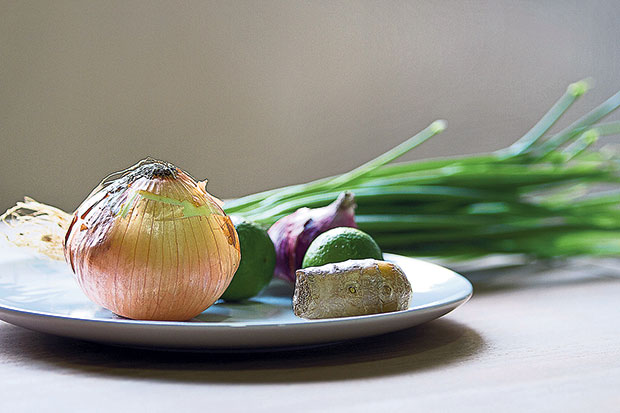 Some of the ingredients used to flavour the pho — onions (white, red, green), ginger and lime.