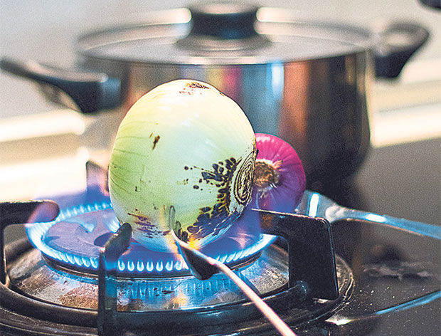 Charring the red and white onions over fire.