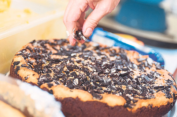 Adding the final touches to one of her cakes.
