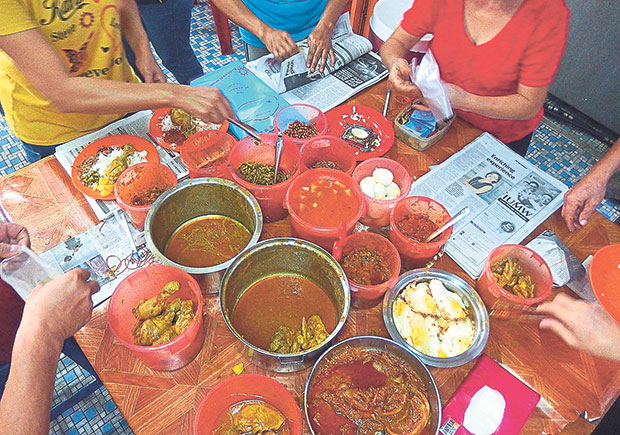 The busy nasi lemak stall in the morning where all hands are on deck to pick out their choices.