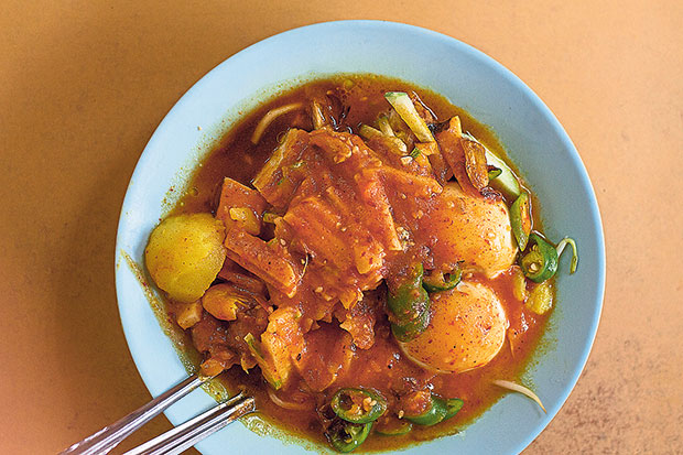 Abdul Rahim’s mee kahwin is an inspired pairing of mee rebus and rojak — blanched yellow noodles are topped with taukua (fried beancurd), hard-boiled egg, potato cubes, fresh bean sprouts, crunchy cucur udang (prawn fritters), and cut green chillies.