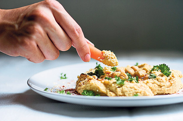 Dip a baby carrot or other crudité of choice into the hummus and enjoy!