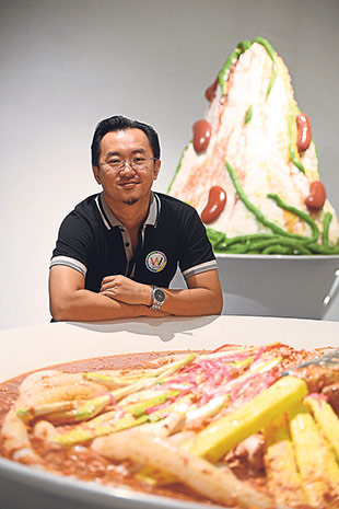 Sean Lau with the giant laksa in front and cendol in the background at his Wonderfood Museum.