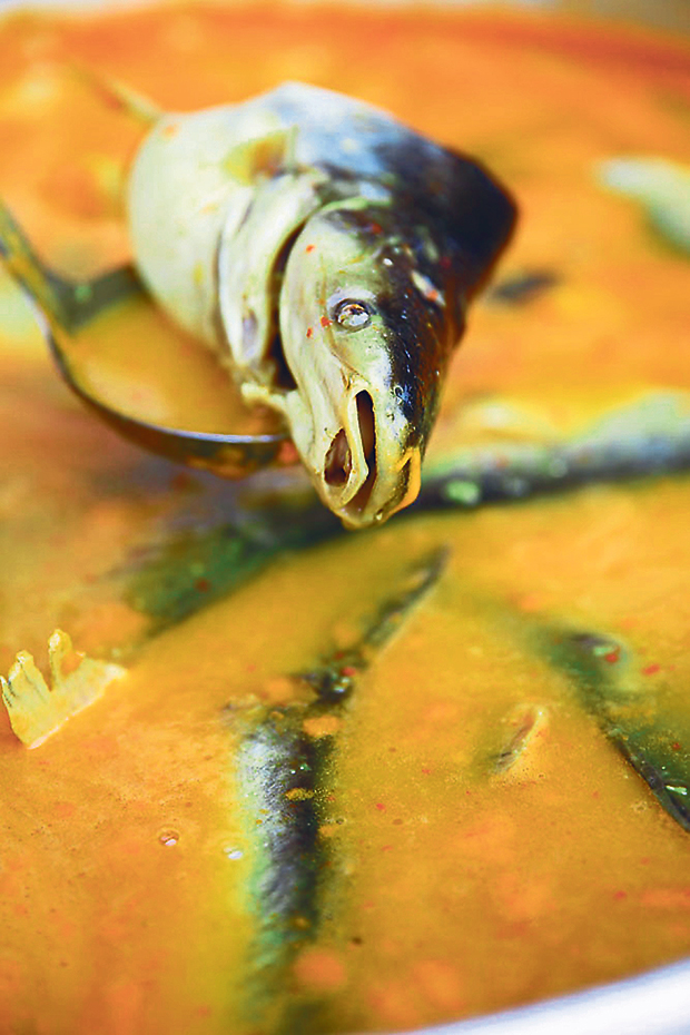 Help yourself to a piece of ikan patin from the pot and ladle the curry over it