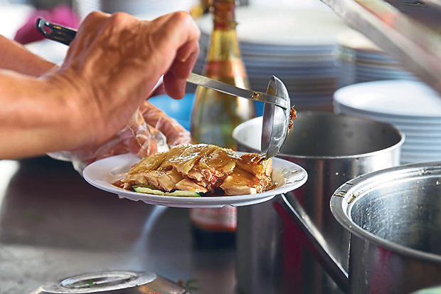 Just before serving, Yong Ban Thong adds a mix of soy sauce and sesame oil over the poached chicken