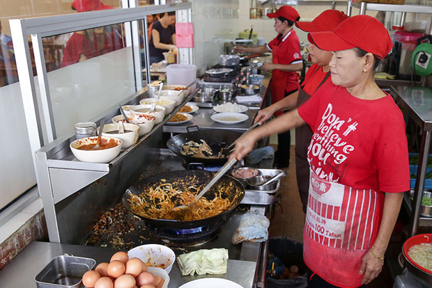 The lye fun noodles are fried in a wok with the bean sprouts and the special laksa sauce.