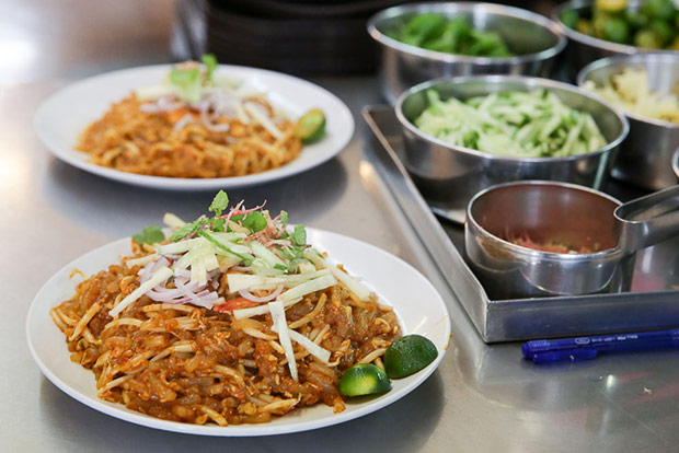 Once it is plated up, the fried laksa is garnished with pineapple, cucumber, onions, fresh mint leaves, torch ginger flower and calamansi lime.