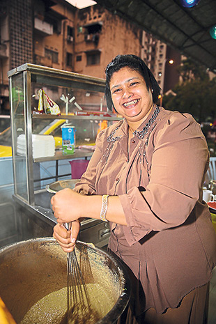 Hyderabad Biryani House owner Saira Banu helps out to stir the haleem.