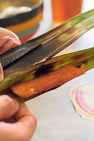 Unwrap the slightly charred banana leaves to reveal the umami-rich otak-otak within.