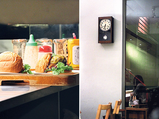 Cooked-to-order burgers, ready to be served (left). A vintage clock on the wall of For Farm Burger, a low-key, natural-themed café (right).