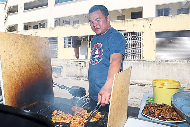In the kitchen, marinated pork chops are grilled over a hot charcoal fire at Mimi Nguyen Cafe.