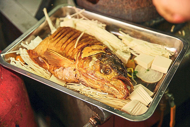 The Song fish head is pre-fried and laid on the tray with the enoki mushrooms, bean curd and preserved white radish.