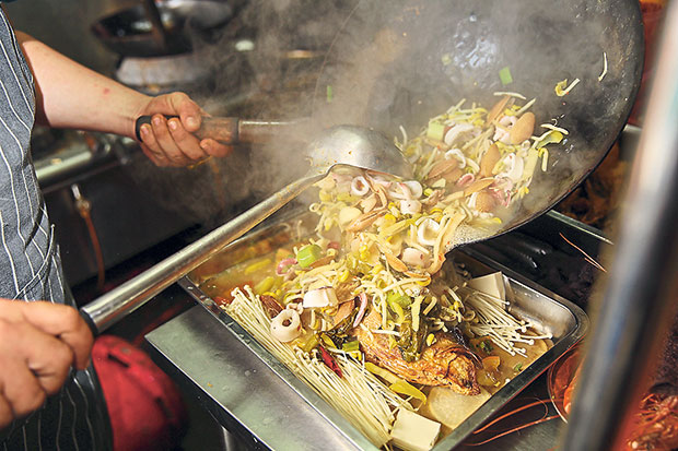 Once the broth is cooked with the vegetables and seafood is ready, it’s poured into the tray.