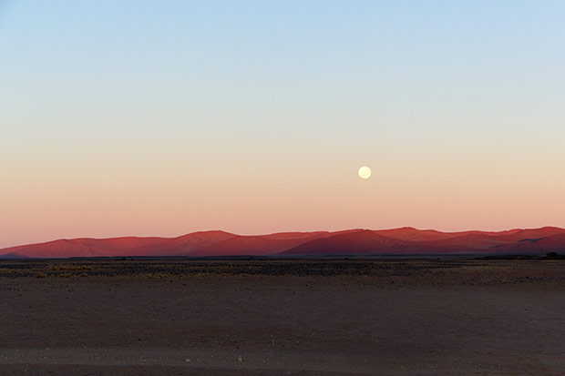 A desert moon during the day.
